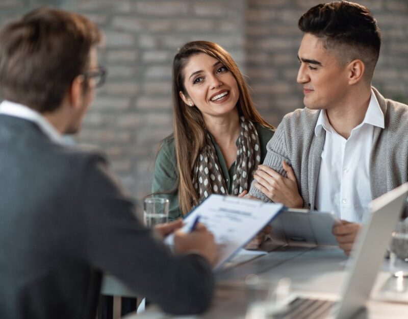 Young couple talking to a mortgage broker about refinancing