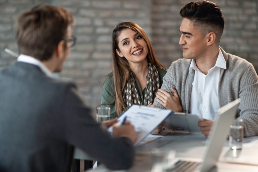 Young couple talking to a mortgage broker about refinancing